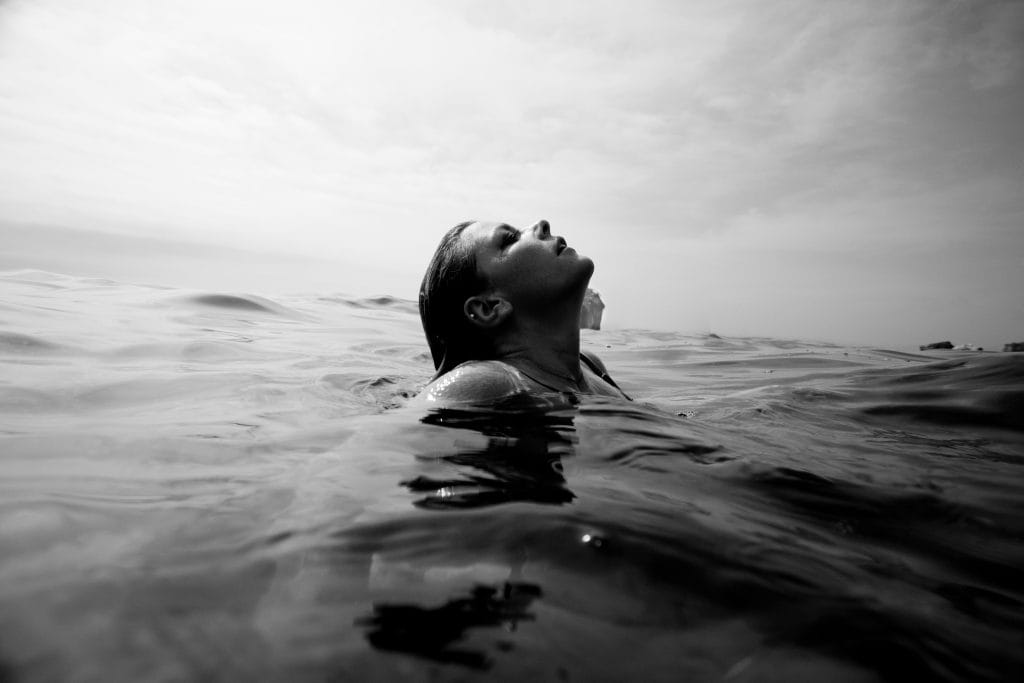 Person surfacing from water, taking a deep breath — symbolising clarity and calm through better breathing techniques
