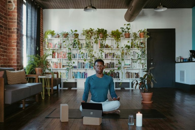 Person practising breathing exercises for anxiety, seated calmly indoors with soft natural light.