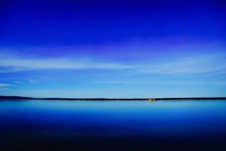 Calming blue horizon over still water representing nervous system regulation and a sense of clarity and composure.